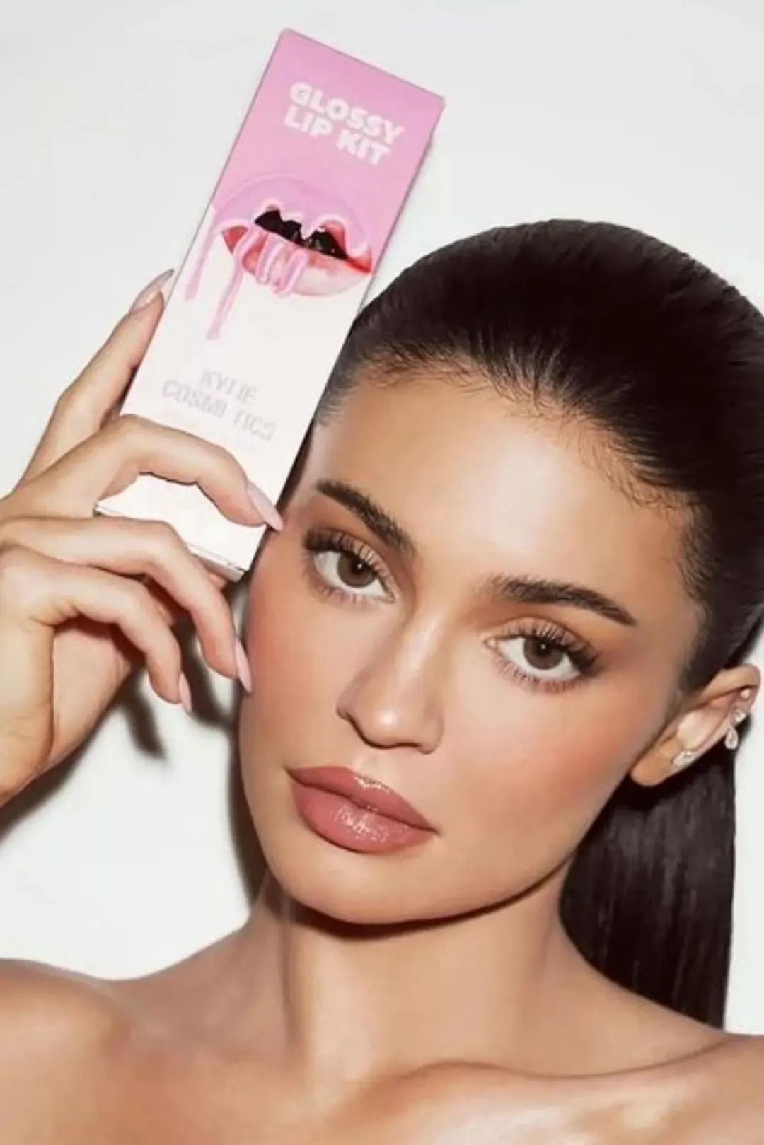 Kylie Cosmetics kurucusu ürün kutusunu yüzünün yanında tutarken
