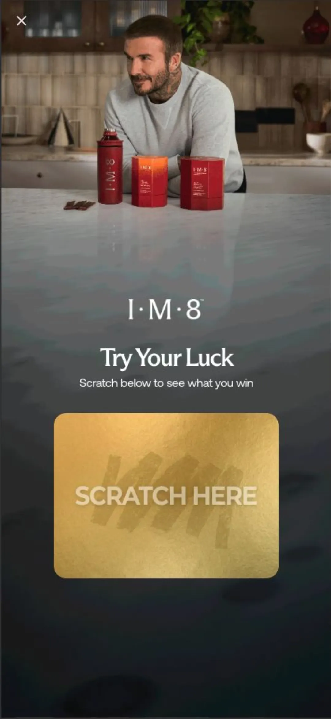 IM8 sitesindeki “Try Your Luck” kazı-kazan pop-up'ı, altın renkli SCRATCH HERE kartı