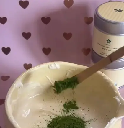 Aynı videoda beyaz çikolata kâsesine matcha tozu ekleniyor, ürünün göründüğü kısa an